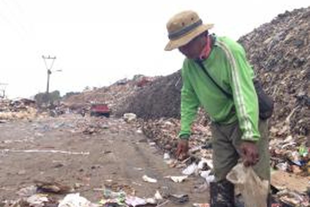 Sono (44) terlihat sedang memilah sampah di Tempat Penampungan Sampah Terpadu (TPST) Bantar Gebang pada Rabu (4/11). 