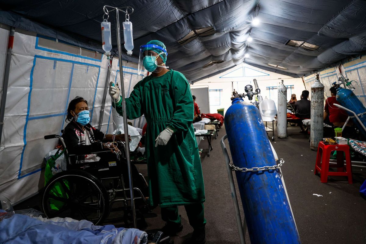 Tenaga medis membantu memasang infus kepada pasien di tenda darurat di depan instalasi gawat darurat (IGD) Rumah Sakit Umum Daerah (RSUD) Cengkareng, Jakarta Barat, Kamis (24/6/2021). Meningkatnya kasus Covid-19 di ibu kota dalam beberapa hari terakhir mengakibatkan penuhnya tingkat keterisian kamar perawatan di rumah sakit tersebut sehingga sebagian pasien Covid-19 terpaksa menempati tenda darurat.