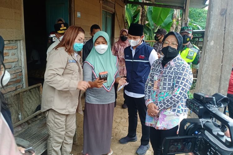 Menteri Sosial Tri Rismaharini bersama Bupati Trenggalek Mochamad Nur Arifin menyaksikan pencarian bansos milik salah satu warga KPM di Desa Melis, Kecamatan Gandusari, Kabupaten Trenggalek, Jawa Timur, Sabtu (25/12/2021).