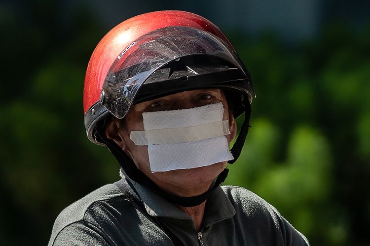 Seorang pria mengenakan lembaran tisu yang diplester sebagai pengganti masker untuk pencegahan terhadap penyebaran virus corona (Covid-19), di Kuala Lumpur, Malaysia, Rabu (25/3/2020).