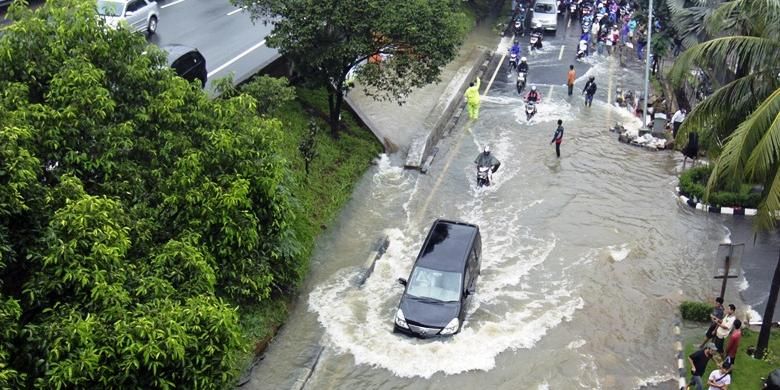 Suasana ketika sebuah mobil menerobos banjir yang terjadi di sekitar kawasan TB Simatupang, Jakarta Selatan, Senin (12/1/2014). Banjir ini terjadi akibat curah hujan yang tinggi di kawasan ibukota yang terjadi sejak Minggu malam (11/1/2014). 