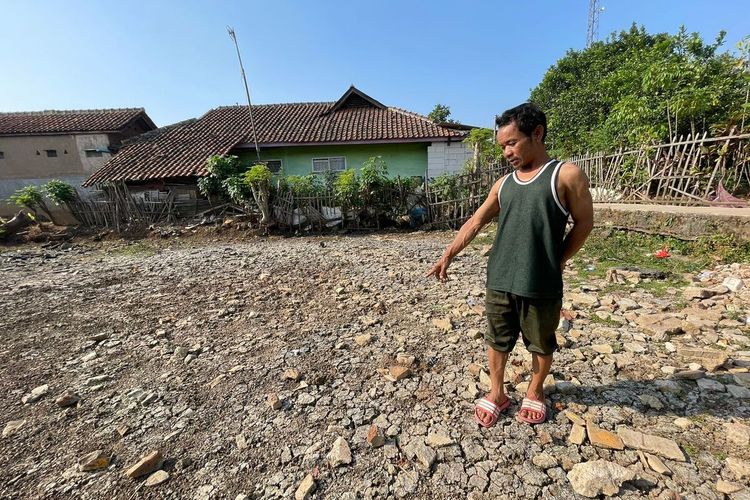 Ehor Rohman Ketua RT 03 RW 01 dan seorang warga Kampung Warung Cina, Desa Linggar, Kecamatan Rancaekek, Kabupaten Bandung, Jawa Barat tengah menunjukan kolam penampungan yang mengering pada Senin (21/8/2023)