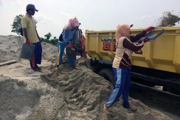 Para buruh menaikkan pasir di tempat penampungan pasir di Desa Pandan, Kecamatan Galis. Pengusaha di Desa ini dikenai pungli oleh oknum Polisi.