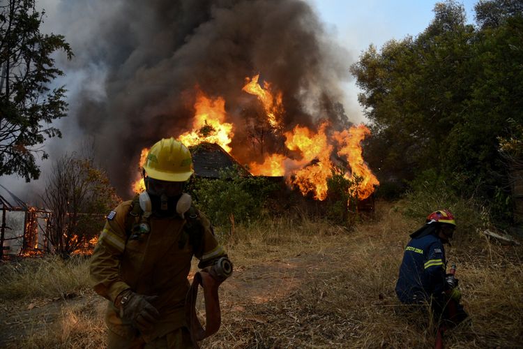 Petugas pemadam kebakaran bekerja memadamkan api kebakaran hutan, di Labiri, dekat Patras, pada Sabtu, 31 Juli 2021, ketika terjadi kebakaran besar kedua dalam beberapa hari, empat desa dekat Patras dievakuasi. [STR/Eurokinissi/AFP]