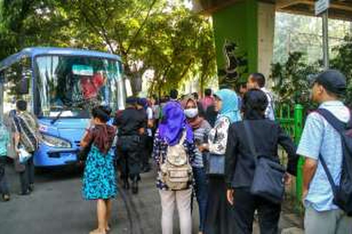 Penumpang yang baru keluar Stasiun Tebet mengantre di kolong flyover untuk menaiki feeder transjakarta yang melayani rute 6 Kuningan, Kamis (7/4/2016).