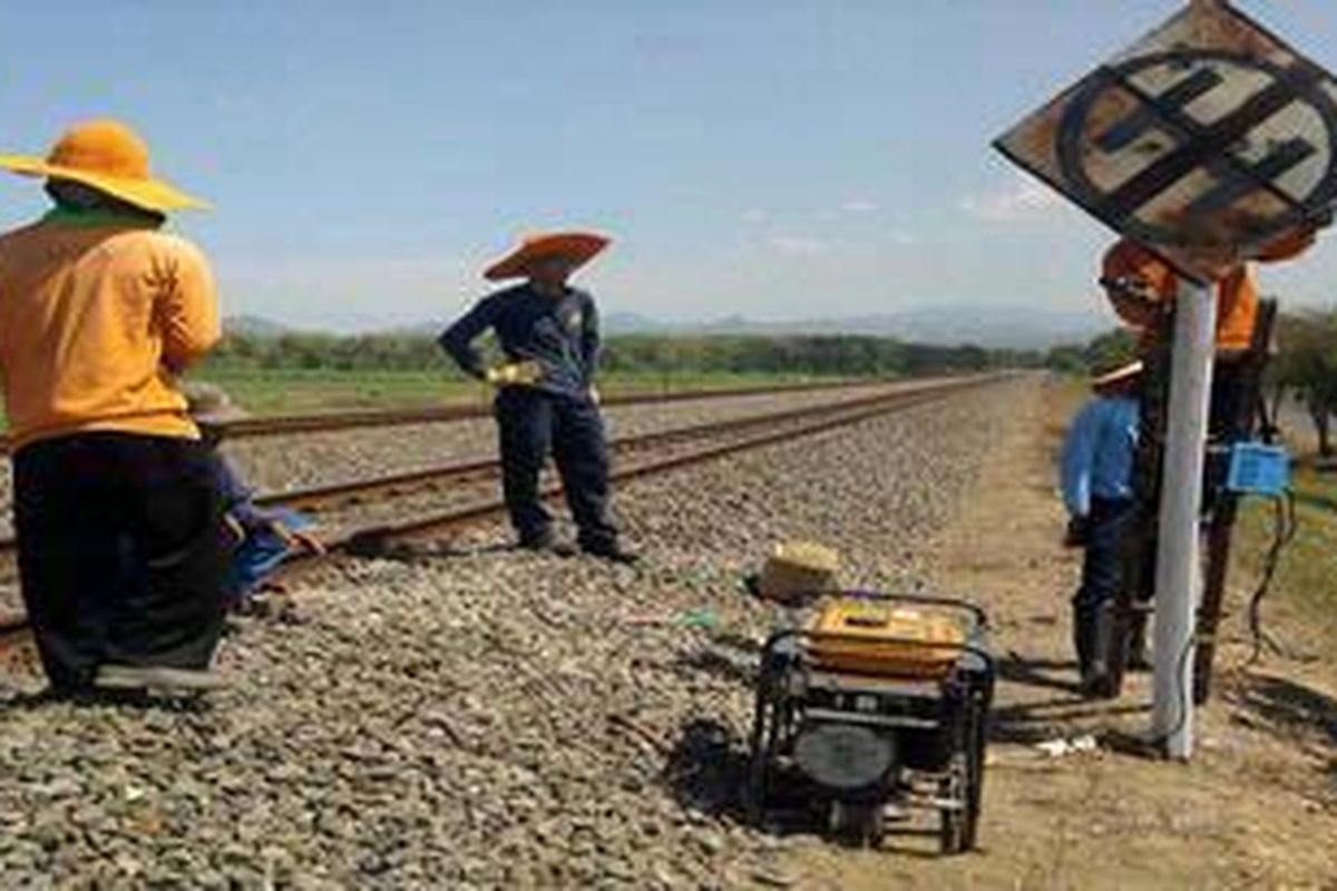 Sejumlah petugas PT KAI memperbaiki rambu di jalur kereta, megantisipasi arus mudik.