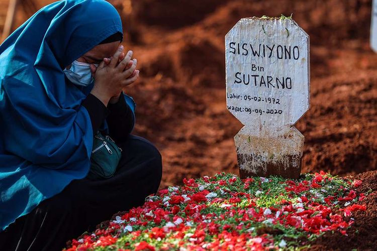 Keluarga berdoa ke jenazah pasien suspect virus corona atau Covid-19 di TPU Pondok Rangon, Jakarta Timur, Kamis (9/9/2020). Petugas administrasi TPU Pondok Ranggon mengatakan saat ini jumlah makam yang tersedia untuk jenazah dengan protokol COVID-19 tersisa 1.069 lubang makam, dan diperkirakan akan habis pada bulan Oktober apabila kasus kematian akibat COVID-19 terus meningkat.