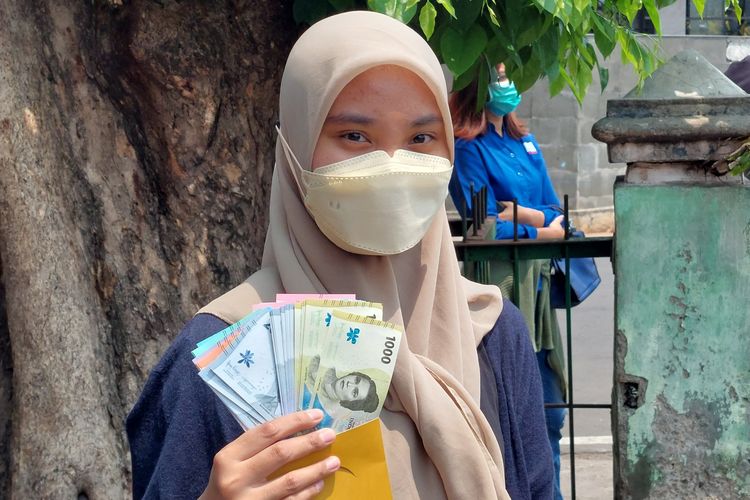 Erina (22) warga Jakarta Barat, rela mengantre panjang demi mendapatkan uang baru di layanan mobil keliling Bank Indonesia di Pasar Slipi, Palmerah, Jakarta Barat, Kamis (25/8/2022).