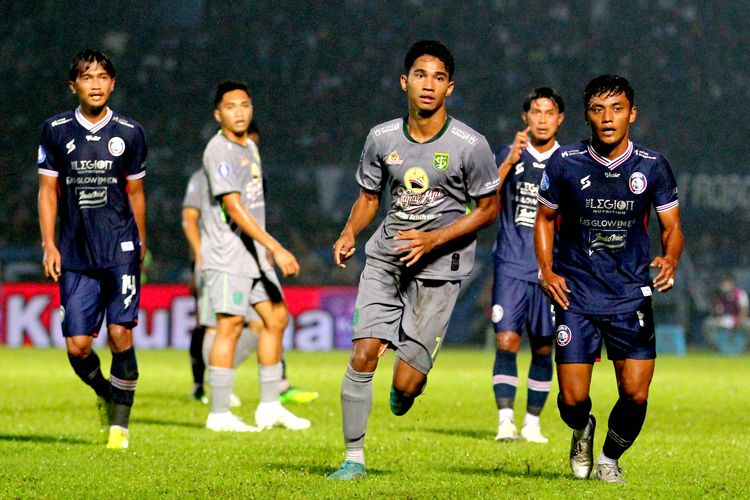 Pemain muda Persebaya Surabaya Marselino Ferdinan (tengah) dijaga ketat pemain Arema FC Irsyad Maulana saat pertandingan pekan ke-11 Liga 1 2022-2023 yang berakhir dengan skor 2-3 di Stadion Kanjuruhan Kepanjen, Kabupaten Malang, Sabtu (1/10/2022) malam.