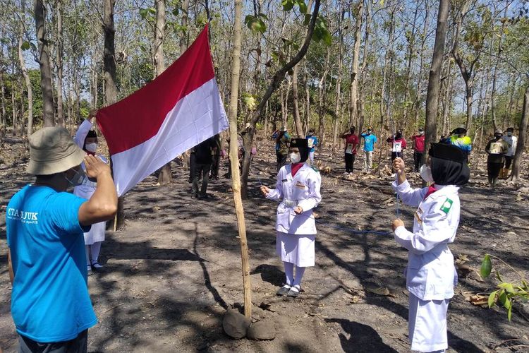 Prosesi pengibaran bendara merah putih saat upacara bendera di hutan Desa Ngadiboyo Nganjuk, Selasa (17/8/2021). Salah satu yang bertugas menjadi Paskibra ialah Rizky Kurniawati yang kemudian hak sepatunya copot.