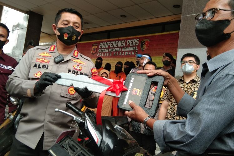 Kapolres Karawang AKBP Aldi Subartono saat secara simbolis menyerahkan kunci motor warga yang kendaraannya sempat dicuri, Jumat (4/3/2022).