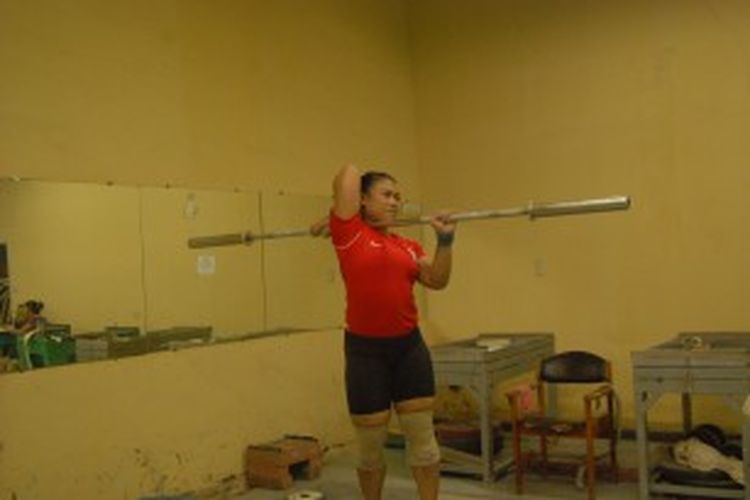 Atlet angkat besi pelatnas kelas 63 kilogram, Sinta Darmariani, sedang melakukan pemanasan sebelum mulai latihan rutin di pelatnas angkat besi, Senayan, Rabu (3/7/2013).