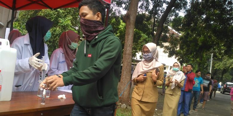 Warga mengantre dengan social distancing saat mengantre pembagian hand sanitizer gratis di FMIPA Unila, Senin (23/3/2020). 40 liter cairan hand sanitizer dibuat untuk dibagikan ke masyarakat