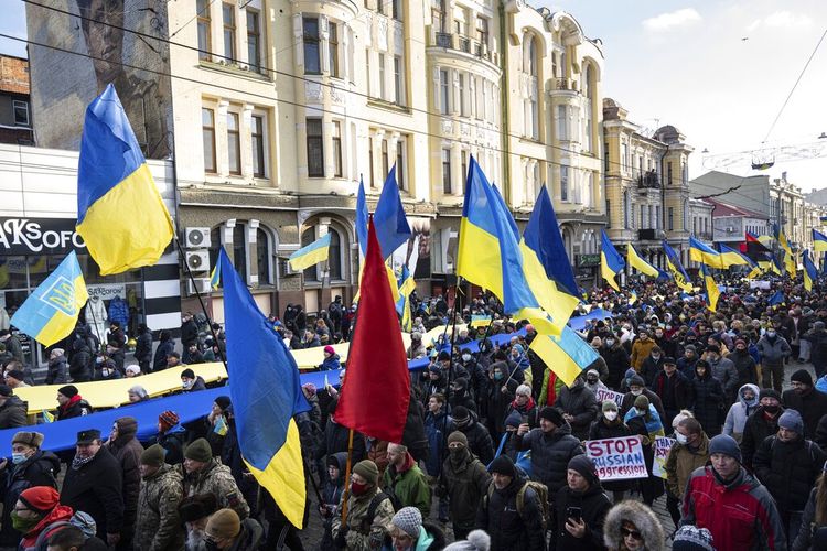 Demonstran dengan bendera nasional Ukraina berunjuk rasa menentang agresi Rusia di pusat Kharkiv, kota terbesar kedua di Ukraina, Sabtu, 5 Februari 2022, hanya 40 kilometer (25 mil) dari puluhan ribu tentara Rusia yang berkumpul di perbatasan dari Ukraina.