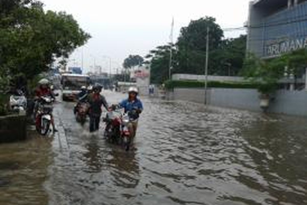 Sejumlah warga yang sepeda motornya mengalami mogok saat melewati banjir di Jalan S Parman, tepat di depan Universitas Tarumanagara, Jakarta Barat, Rabu (5/2/2014)