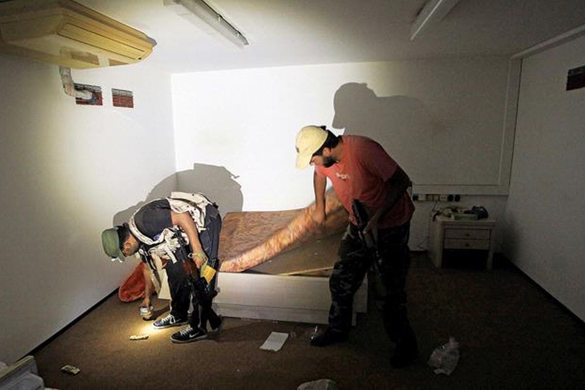 Personel  oposisi menggeledah ruangan di dalam bungker di kompleks kediaman Moammar Khadafy di Bab al-Aziziya, Tripoli, Libya, Kamis (25/8). Pemimpin oposisi Libya menawarkan hadiah hingga 2 juta dollar AS bagi orang yang berhasil menangkap Khadafy. Pemimpin Libya tersebut menolak menyerah dan hingga kini belum diketahui keberadaannya.