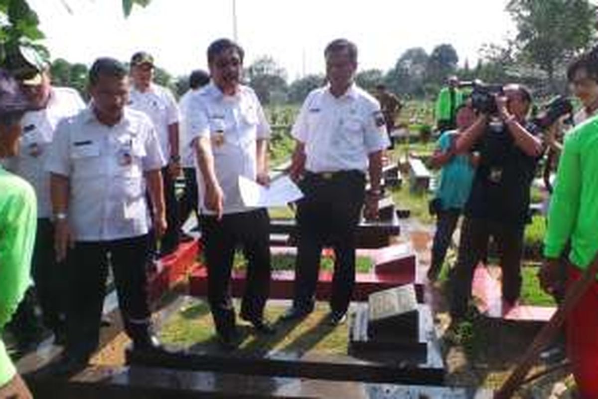 Wakil Gubernur DKI Jakarta Djarot Saiful Hidayat bersama Kepala Suku Dinas Pertamanan dan Pemakaman Jakarta Pusat Mujirin saat membongkar makam fiktif di TPU Karet Pasar Baru Barat, Rabu (3/8/2016).