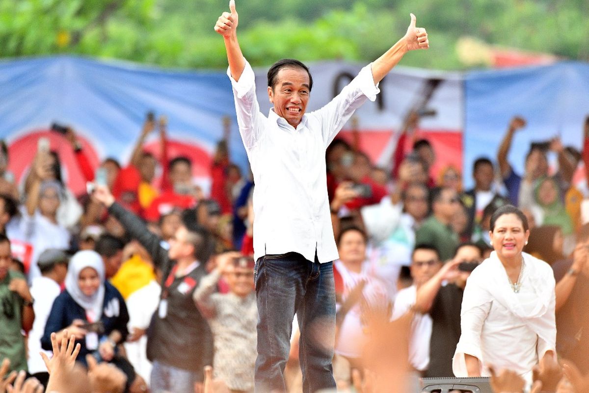Capres petahana Joko Widodo dan sang istri Iriana Jokowi mengacungkan jempol di acara kampanye terbuka di Taman Bukit Gelanggang, Kota Dumai, Provinsi Riau, Selasa (24/3/2019).