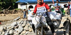 Salah seorang pekerja Pertamina mendistribusikan BBM di daerah yang susah terjangkau.