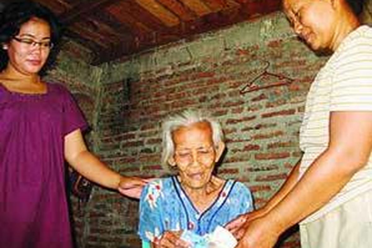 Sopiah (63), (tengah), warga Kecamatan Semarang Utara, menerima bantuan dari tetangganya, Jumilah (50), sebesar Rp 105.000, Selasa (27/5). Mengetahui ada beberapa warga yang tidak mendapat bantuan langsung tunai (BLT), warga setempat berinisiatif menyisihkan uang untuk dibagikan kepada warga yang juga membutuhkan.  