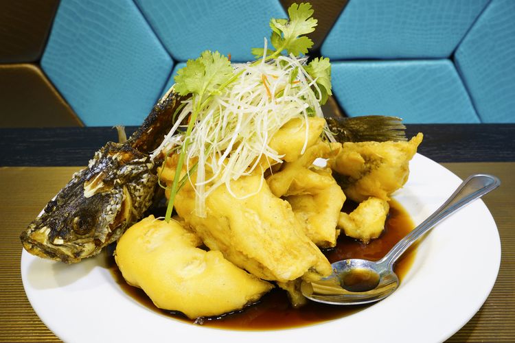 Ilustrasi ikan kakap goreng garing dengan saus. 
