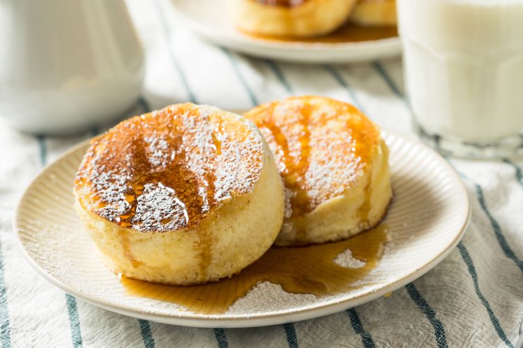 Ilustrasi fluffly pancake ala Jepang dengan taburan gula bubuk dan sirup mapel. 