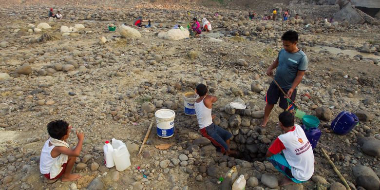 Warga memanfaatkan sisa air di Sungai Cibarusah, Kampung Ciketung, Desa Sirnajati, Kecamatan Cibarusah, Kabupaten Bekasi, Jawa Barat untuk keperluan mandi dan mencuci, Minggu (16/8/2015). Warga mengaku kesulitan mendapatkan air bersih sejak tiga bulan terakhir karena sumur dan sungai mereka mengering akibat kemarau. KOMPAS IMAGES/KRISTIANTO PURNOMO
