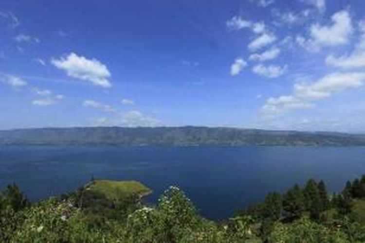 Danau Toba terlihat dari Parapat, Kabupaten Simalungun, Sumatera Utara, Senin (25/7/2011). Danau Toba adalah danau terbesar di Indonesia. Danau hasil volcano tektonik terbesar di dunia, dengan panjang danau 87 kilometer dan lebar 27 kilometer, terbentuk dari letusan gunung berapi raksasa (supervolcano) yang terjadi sekitar 75 ribu tahun lalu. 