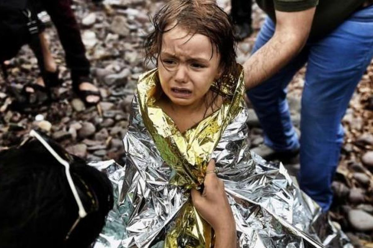 Seorang anak perempuan pengungsi Suriah menangis saat tiba di Pulau Lesbos, Yunani, setelah menyeberangi laut Aegean dari Turki, 28 September 2015. 