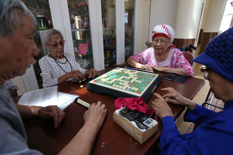 Soewarni Mansjoer (kedua dari kiri), lansia di Sasana Tresna Werdha RIA Pembangunan, Cibubur, Jakarta Timur, tengah bermain scarbble, Kamis (22/8/2019). Ia dulu seorang profesor ahli farmasi.