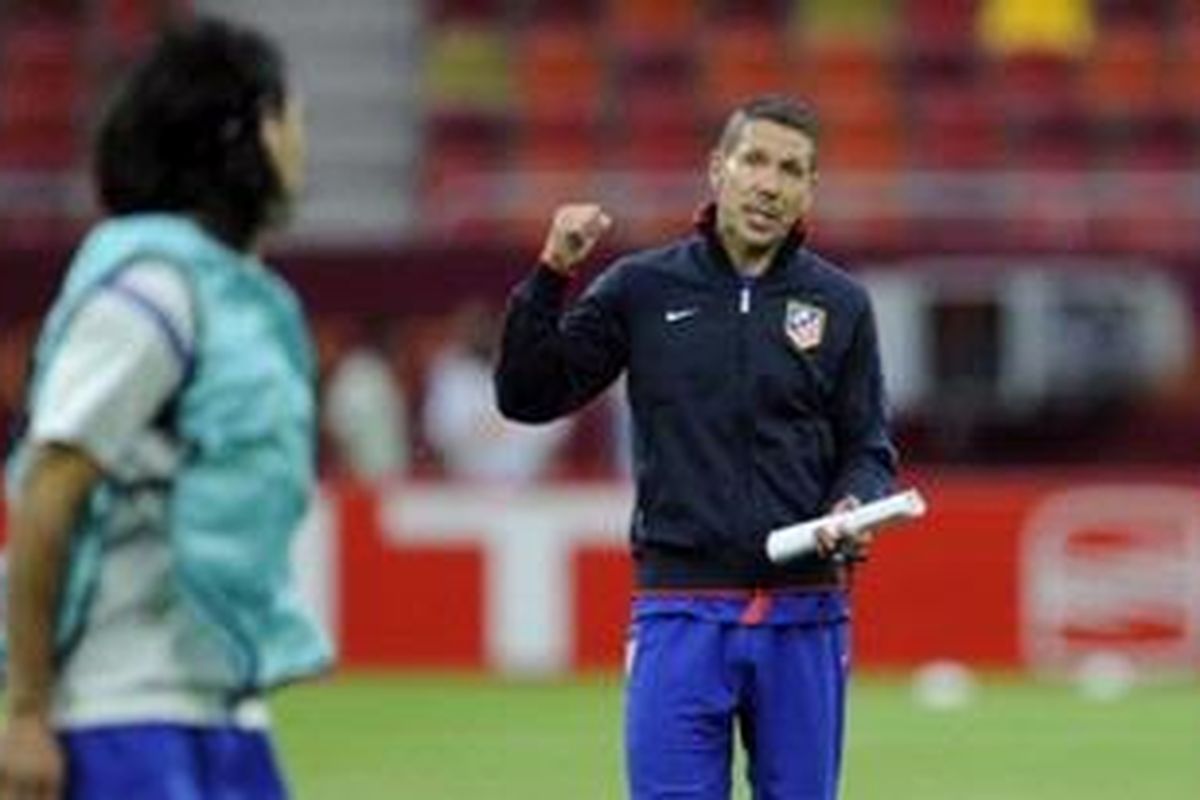 Pelatih Atletico Madrid (kanan) memberi instruksi kepada strikernya, radamel Falcao, dalam sebuah latihan.