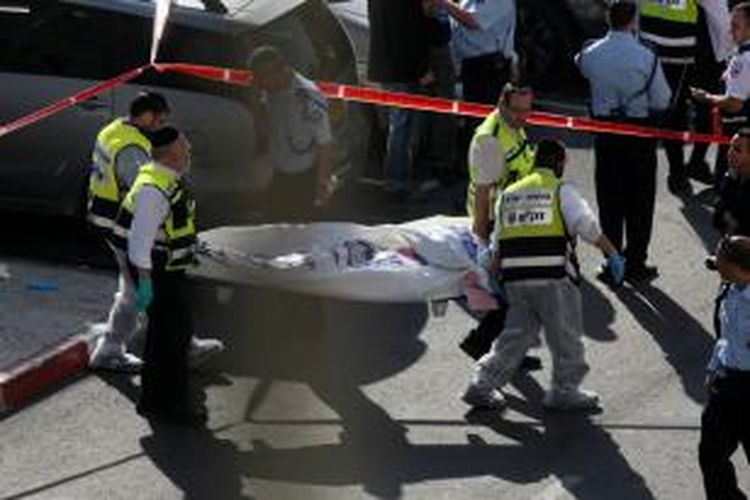 Tim para medis Israel mengangkat jasad salah satu pria Palestina pelaku serangan maut ke sebuah sinagoga di kota Jerusalem, Selasa (18/11/2014), yang mengakibatkan empat orang warga Israel tewas.