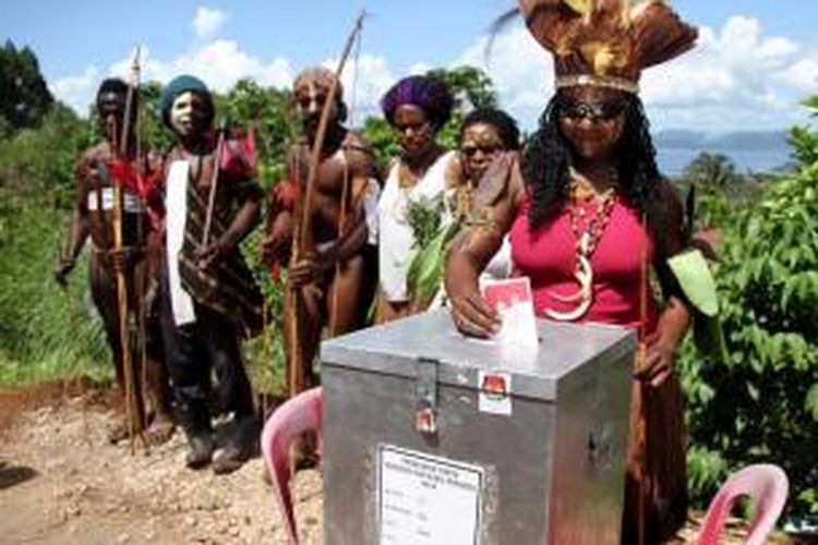 Warga Papua mengenakan pakaian tradisional saat menggunakan hak suaranya dalam Pemilu Presiden 2014 di Jayapura, Rabu (9/7/2014). Pemilu memilih dua calon presiden yaitu Prabowo Subianto berpasangan dengan Hatta Rajasa dan Joko Widodo berpasangan dengan Jusuf Kalla.