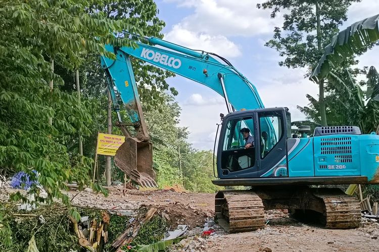 Sebuah beko terlihat masih melanjutkan pengerjaan proyek saringan sampah di Kali Ciliwung, Kelurahan Gedong, Kecamatan Pasar Rebo, Jakarta Timur, Kamis (15/12/2022).