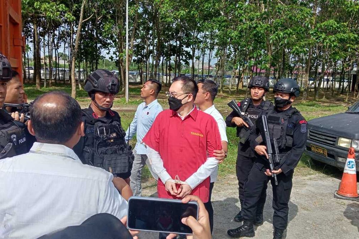 Tersangka kasus dugaan judi online, Apin BK diapit penyidik Polda Sumut saat penyerahan berkas, tersangka dan barang bukti kasusnya kepada Kejaksaan Tinggi Sumatera Utara pada Kamis (26/1/2023) sore.