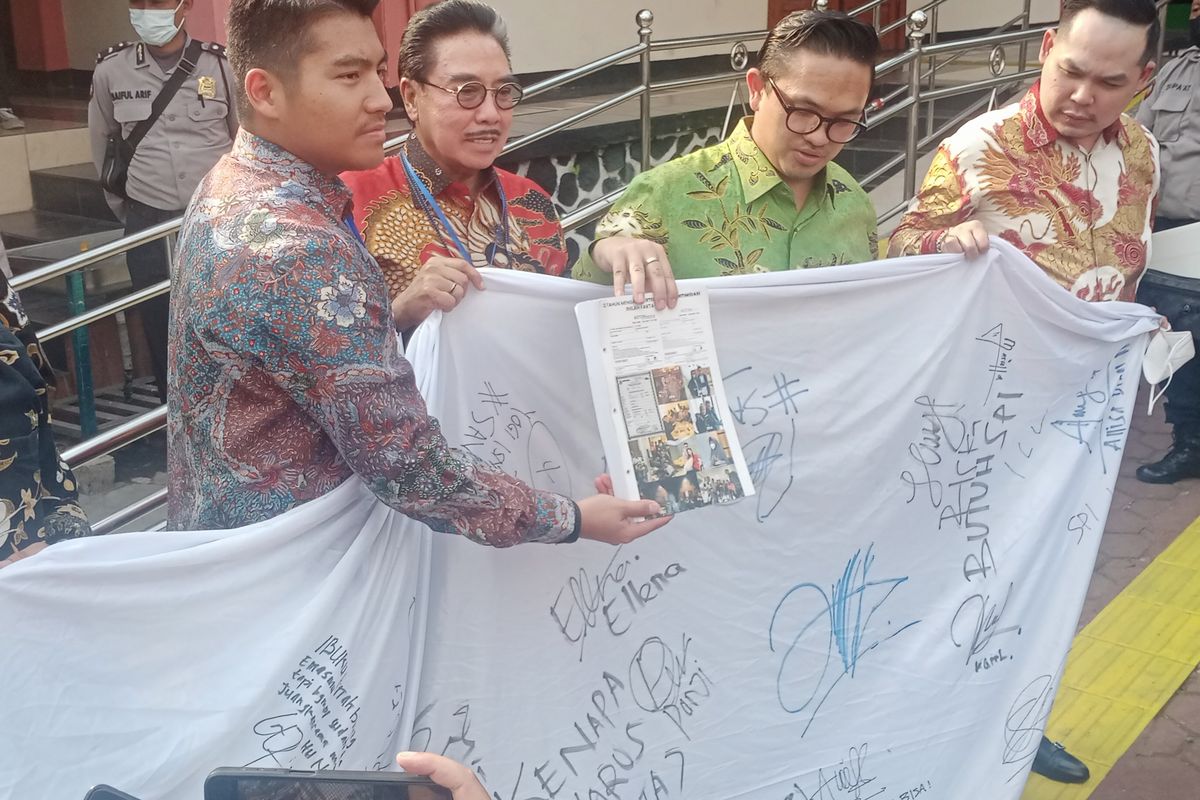 Ketua Tim Kuasa Hukum Terdakwa, Hotma Sitompul bersama lainnya membawa bentangan kain berisikan tanda tangan petisi dari 100 siswa dan alumni yang meminta keadilan bagi JEP dapat dibebaskan dari tuntutan yang ada dalam persidangan di Pengadilan Negeri Malang Kelas IA pada Rabu (3/8/2022). 