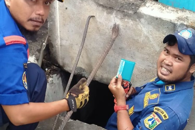 Petugas Gulkarmat Jakarta Utara melakukan evakuasi dompet di dalam selokan di Kelapa Gading, Jakarta Utara, Selasa (28/6/2022).