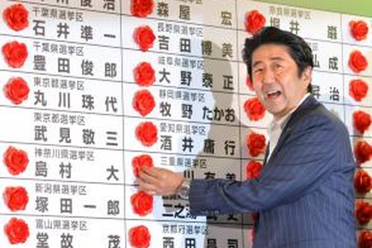 Senyum Perdana Menteri Jepang sekaligus Presiden Partai Demokrat Liberal, Shinzo Abe, seiring kepastian kemenangan partainya di pemilu Majelis Tinggi Jepang, Minggu (21/7/2013). KAZUHIRO NOGI / AFP