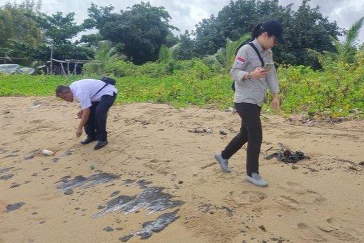 Petugas saat memeriksa limbah tumpahan minyak di pantai di Bangka Tengah, Kepulauan Bangka Belitung