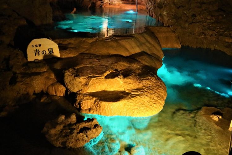 Goa purba Gyokusendo yang ada di Pulau Okinawa. Tampak dalam foto adalah sebuah air terjun kecil dengan air jerni berwarna biru tosca.