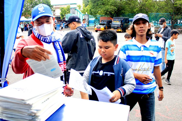 Sejumlah suporter PSIM Yogyakarta mengambil zine salah satu karya komunitas bawahskor sebelum laga babak 12 besar Liga 1 2023-2024 melawan PSMS Medan yang berakhir dengan skor 2-1 di Stadion Mandala Krida Yogyakarta, Jumat (12/1/2023) sore.