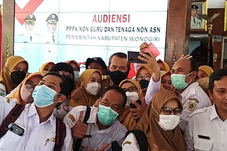 Beberapa pegawai P3K dan tenaga honorer meluapkan kegembiraan mereka dengan berfoto bersama Bupati Wonogiri Joko Sutopo setelah aspirasi mereka dikabulkan. Pegawai P3K meminta adanya tambahan penghasilan pegawai (TPP) dan tenaga honorer meminta tetap diperpanjang masa kerjanya di Pendopo Kabupaten Wonogiri, Senin (5/9/2022).
