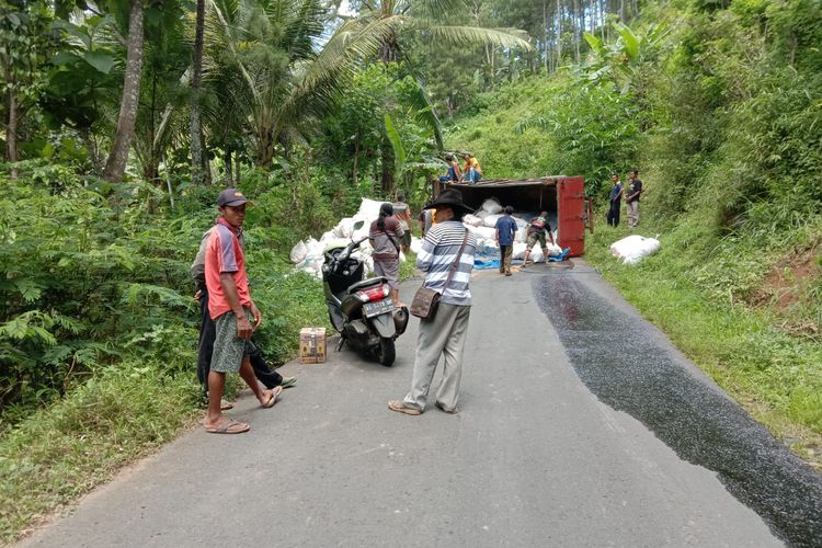 TERGULING--Sebuah truk bermuatan penuh kotoran ayam terguling di ruas jalan raya Ngrayun tepatnya di Slindit, Dukuh Krajan,  Desa Temon, Kecamatan Ngrayun, Kabupaten Ponorogo, Jawa Timur, Senin (11/4/2022). 