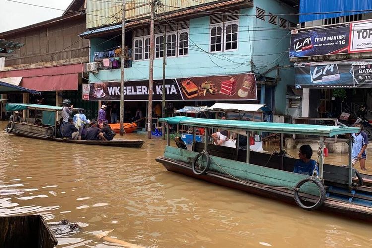 Sejumlah warga menggunakan perahu untuk beraktivitas, karena banjir telah memasuki kawasan pasar di Kota Nanga Pinoh, Kabupaten Melawi, Kalimantan Barat, Sabtu (11/7/2020).