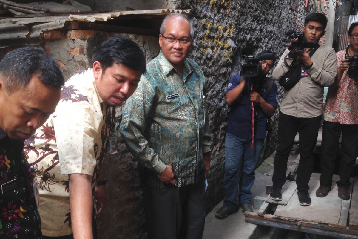 Deputi Gubernur DKI Jakarta Bidang Tata Ruang dan Lingkungan Hidup Oswar Muadzin Mungkasa (tengah) bersama Lurah Duri Utara Denny Aputra saat memantau kondisi tangki septik yang telah dibangun di sekitar rumah warga, Duri Utara, Tambora, Jakarta Barat, Jumat (25/5/2017).