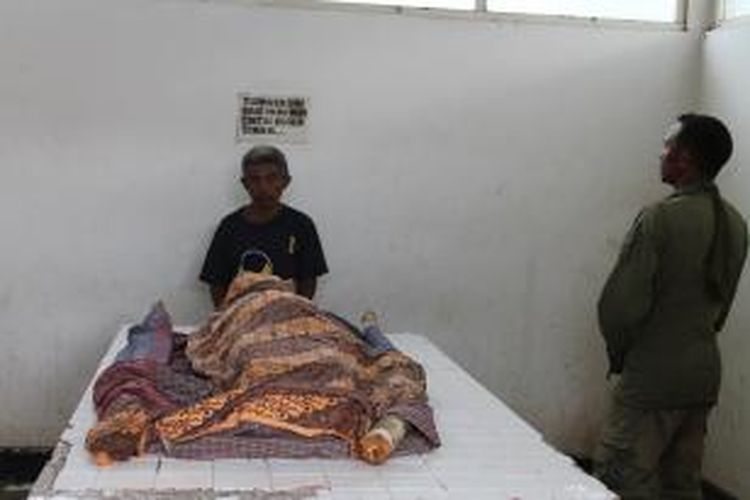 Jasad Theresia Obe yang ditemani suami dan kerabatnya ketika disemayamkan di kamar jenasah RSU Kefamenanu, Kabupaten Timor Tengah Utara (TTU), Nusa Tenggara Timur (NTT), Jumat (26/12/2014)