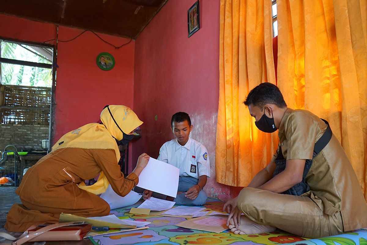 Dua guru SMA Negeri 1 Kabila mengawasi siswa yang melakukan ujian semester secara luar jaringan (luring) di rumah di Poowo, Kabupaten Bone Bolango, Gorontalo, Selasa (9/6/2020). Sejumlah guru di sekolah tersebut mengantarkan soal ujian ke rumah 51 siswa karena tidak memiliki telepon pintar (smart phone) untuk mengikuti ujian dalam jaringan (daring).