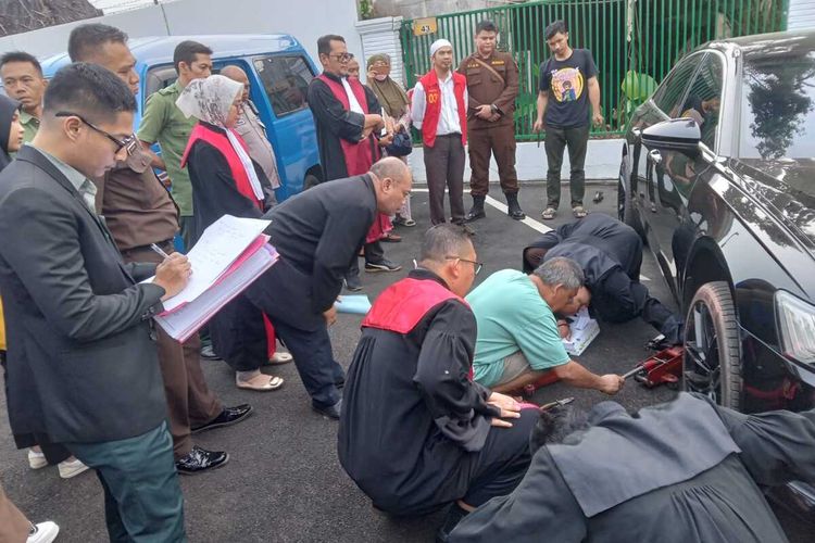 Jaksa memeriksa kondisi sedan Audi yang menjadi barang bukti perkara tabrak lari dengan terdakwa Sugeng Guruh di halaman Pengadilan Negeri Cianjur, Selasa (6/6/2023) petang.