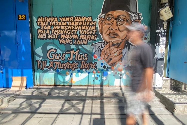 Seorang pengguna jalan melintasi mural bergambar ilustrasi KH A. Mustofa Bisri dan nukilan pemikiran bertema toleransi oleh sosok yang akrab disapa Gus Mus ini di Jl Gatot Subroto, Serengan, Kota Solo, Jawa Tengah, Kamis (8/2/2024. Kota Solo yang selama tiga tahun terakhir menyandang predikat sebagai Kota Toleran menurut lembaga Setara Institute, dikritisi sejumlah kalangan karena dinilai belum inklusif untuk keberagaman gender.
