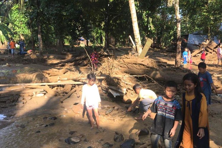 Masyarakat bersama petugas BPBD, Polri, TNI dan pihak lainnya membersihkan sisa-sisa material banjir, akibat banjir bandang yang menerjang Desa Pintu Padang, Kecamatan Ulu Barumun, Kabupaten Padang Lawas, Sumatera Utara, Jumat (12/3/2021) malam. Sedikitnya, 9 rumah dan bangunan habis serta rusak parah. Dan puluhan warga mengungsi.